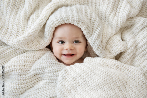 Close up of smiling baby girl wrapped in blanket