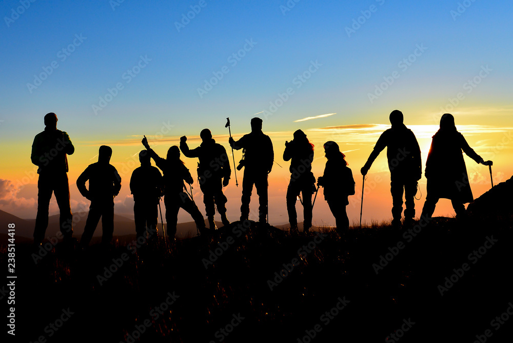 Fototapeta premium crowd of climbers team, walking, summit adventures and tranquility at sunrise time