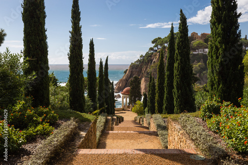 Alley / Way at the coastline to the ocean of the Costa Brava, Spain, against blue sky photo