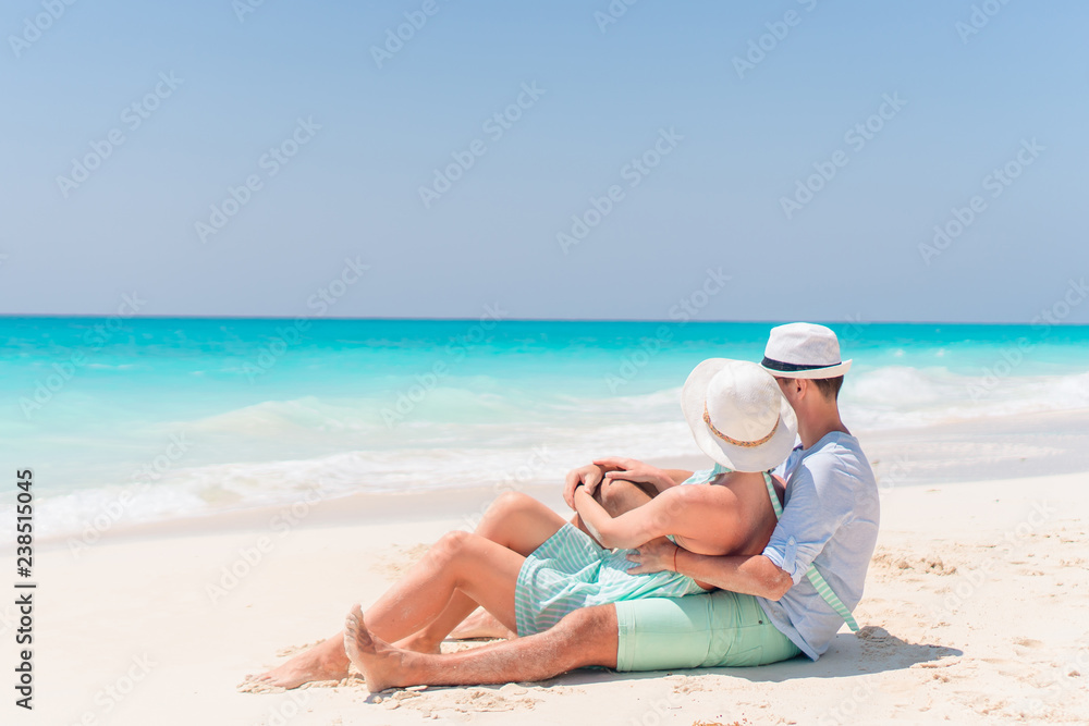 Fototapeta premium Young couple on white beach during summer vacation. Happy lovers enjoy their honeymoon