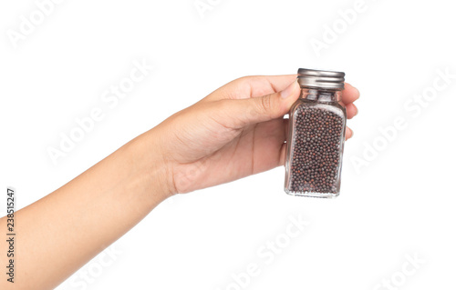 Foto hand holding Bottle of  Black mustard for seasoning isolated on white background