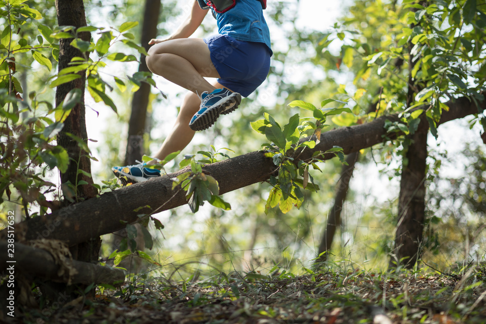Obraz premium Sportswoman cross country trail running in forest