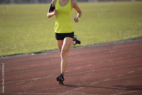 Fitness sportswoman running on stadium race tracks