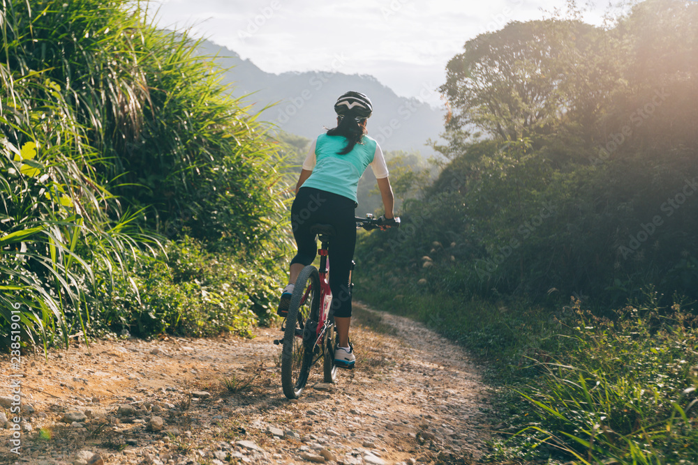 Fototapeta premium Woman cyclist riding a bike on a nature trail in the mountains.people living a healthy lifestyle