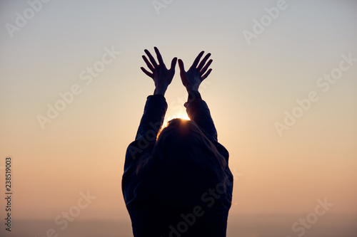 Woman with arms wide open enjoying the sunrise / sunset time.