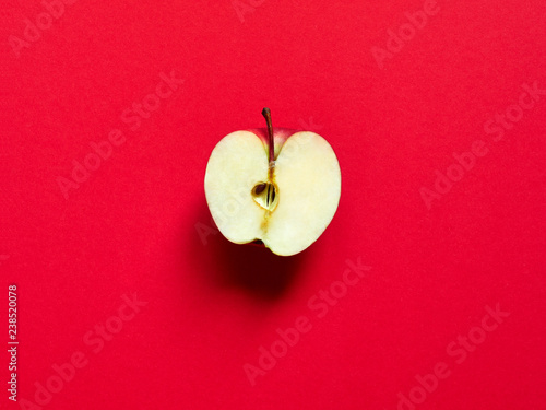 Apple fruit sliced by half isolated in studio over a vivid red background