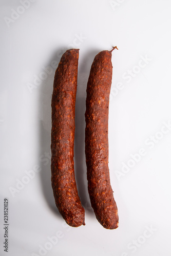 Kiełbasa cienka wędzona na białym tle.