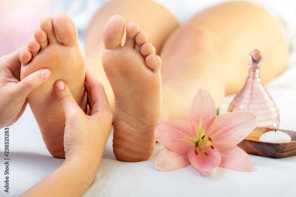 Reflexologist massaging female feet. - obrazy, fototapety, plakaty 