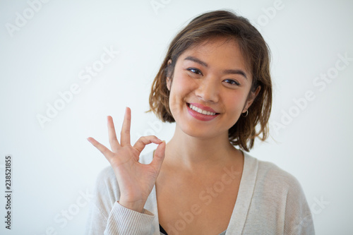 Wallpaper Mural Portrait of happy young woman gesturing alright. Asian girl showing satisfaction sign. Success concept Torontodigital.ca
