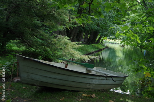A boat at the pond in the park.