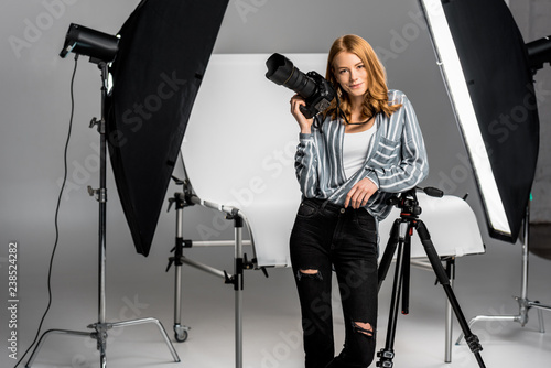 attractive young female photographer working in professional photo studio