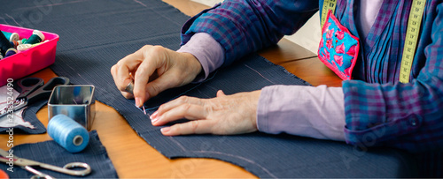 Canvastavla Senior female seamstress sewing cloth to make a garment in her workshop