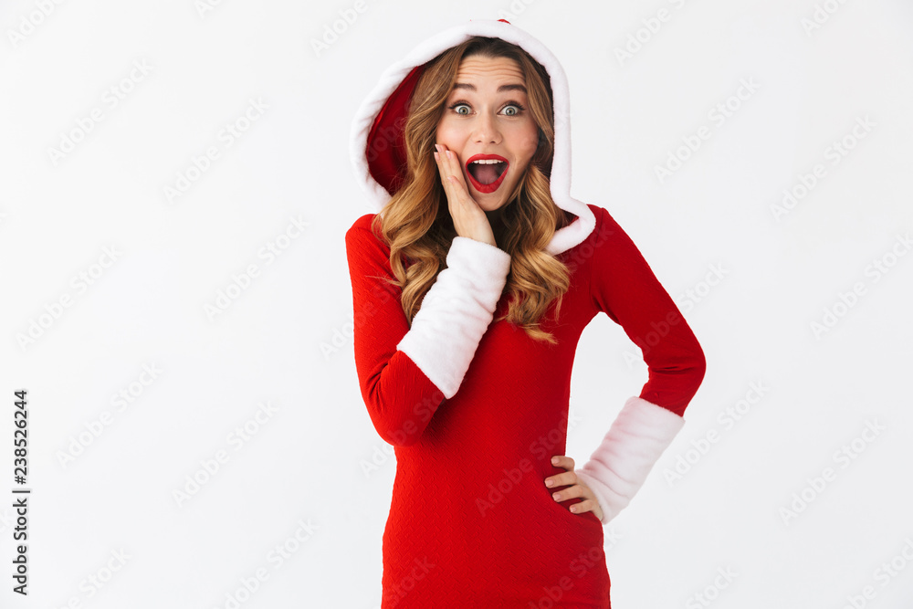 Image of surprised girl 20s wearing Christmas red dress standing, isolated over white background Image of surprised girl 20s wearing Christmas red dress standing, isolated over white background