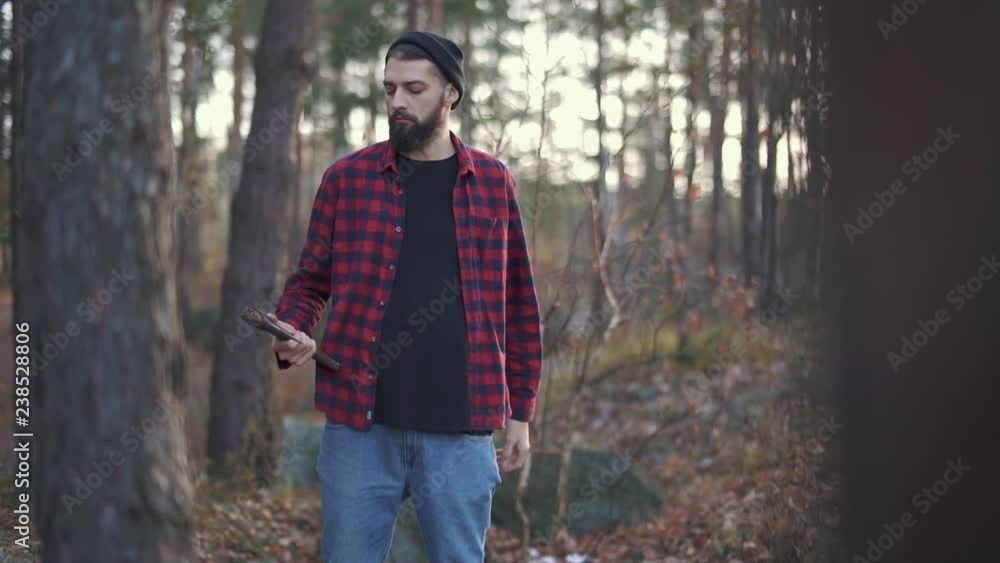 Bearded guy play with his axe, guy throw ax from one hand to another. Brutal man with an axe outdoors. Bearded guy play with his axe, guy throw ax from one hand to another. Brutal man with an axe outdoors.