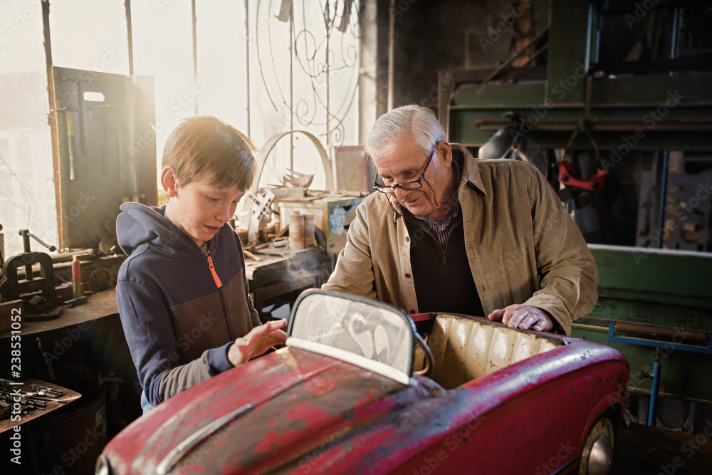 A grandfather and his grandson in the DIY workshop A grandfather and his grandson in the DIY workshop