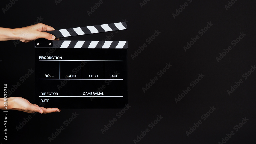 Two Hand's holding Clapperboard or clap board or movie slate use in video production ,film, cinema industry on black background.