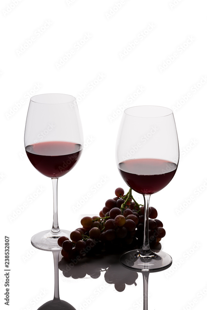 Two glasses of wine and grapes on white background