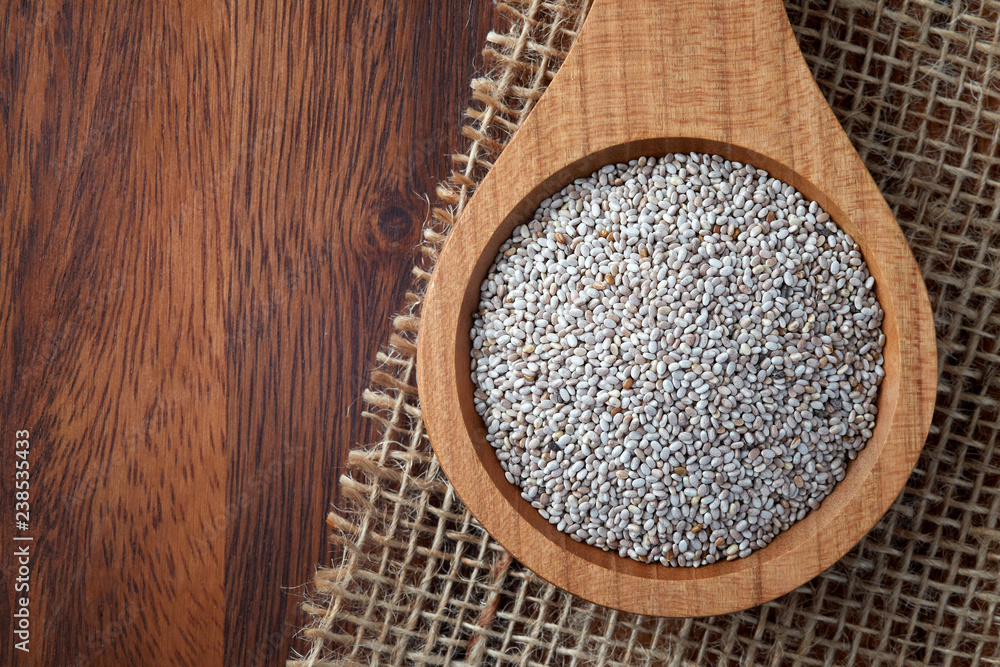 Close up of white chia seeds in wooden spoon. Top view with copy space Close up of white chia seeds in wooden spoon. Top view with copy space