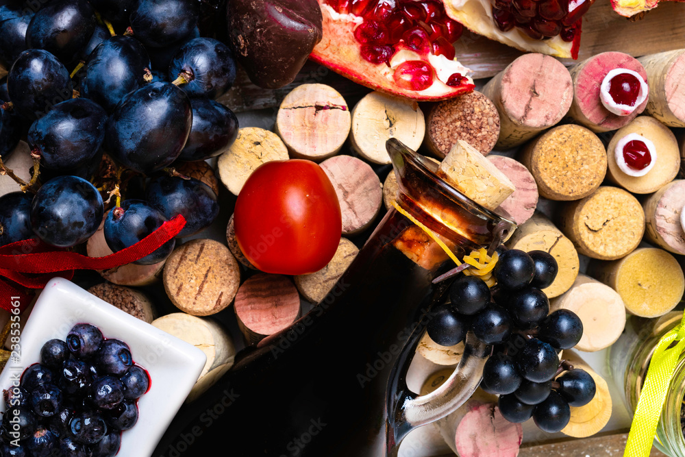 balsamic vinegar in a glass jug with fresh grapes and wine corks and food rich with resveratrol, antioxidants, flavonoids