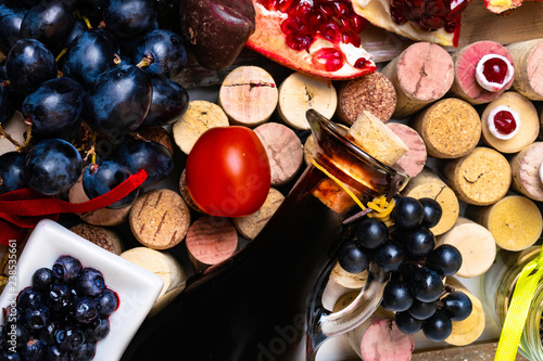 balsamic vinegar in a glass jug with fresh grapes and wine corks and food rich with resveratrol, antioxidants, flavonoids photo