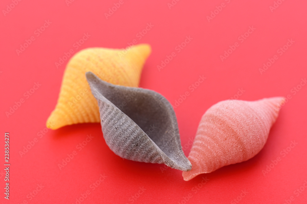 Pasta conchiglie on red background Pasta conchiglie on red background