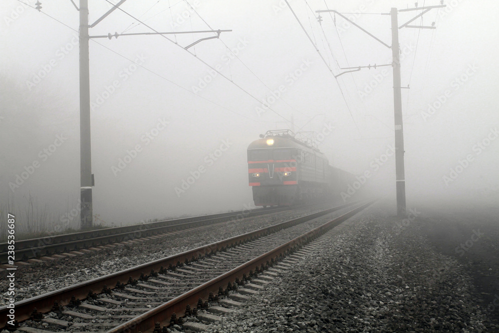 Freight train leaves the fog