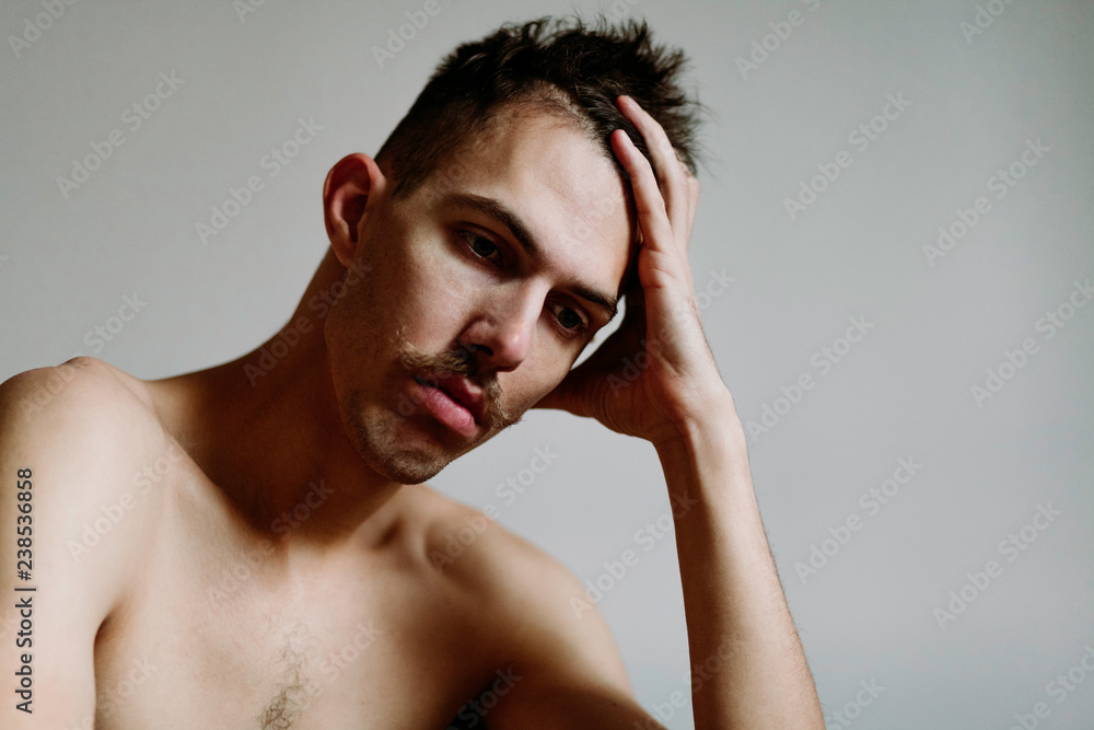 Fototapeta premium Young shirtless man with mustache thinking