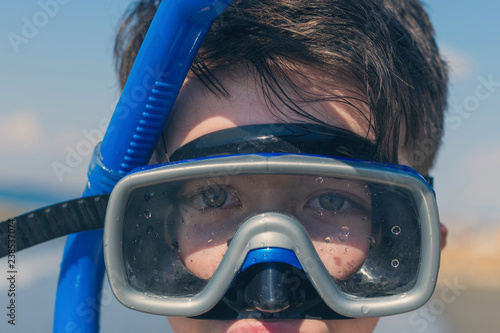 Closeup of boy face in the snorkeling mask. Travel and summer concept. Сhildren's diving