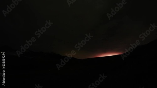 thunderstorm with lightning behind a mountain range