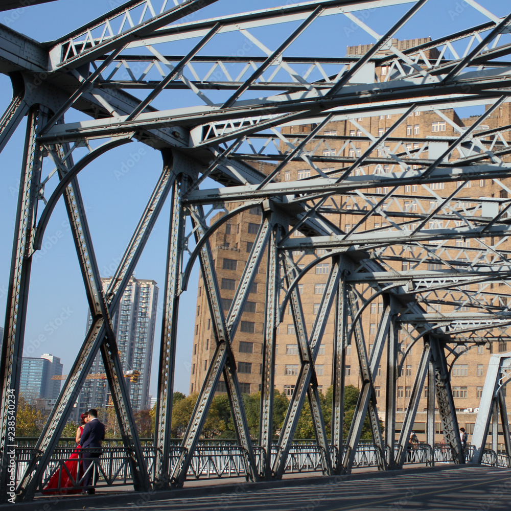 Φωτογραφία Couple - man with woman in a red dress - kissing on a bridge in The Bund area in