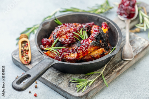 Ribs in honey glaze with cherry sauce and rosemary.