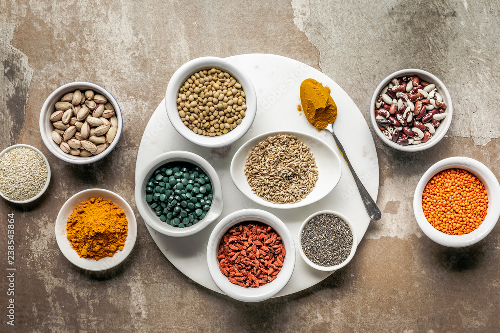 top view of superfoods, nuts and legumes on textured rustic background
