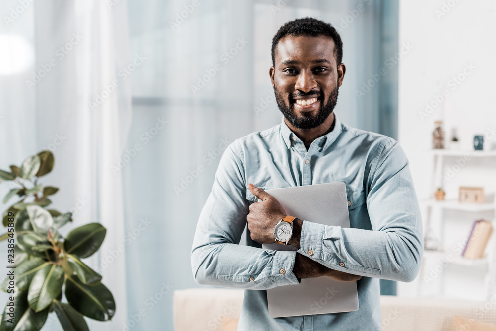 african american freelancer smiling with laptop in hands african american freelancer smiling with laptop in hands
