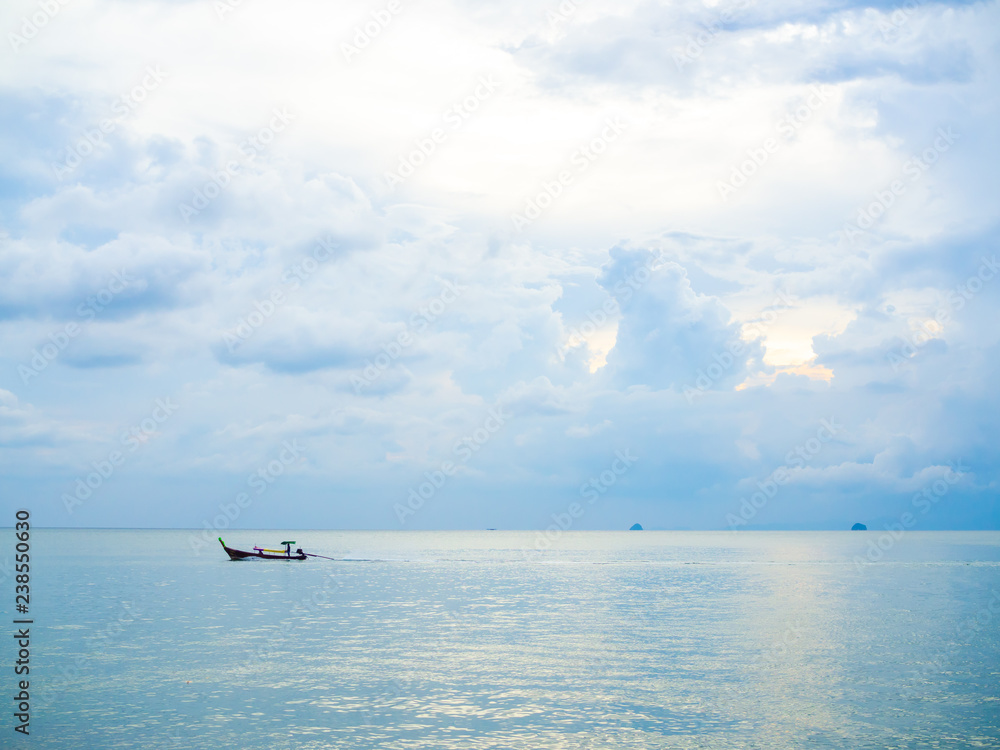 Boat driver on traditional long tail boat in the sea with cloud and sky background on sunset in Thailand minimalist style.