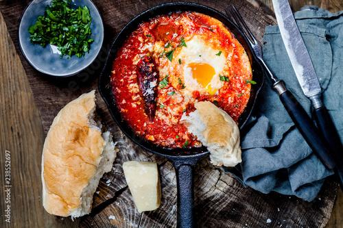 Eggs in Purgatory, eggs, baked in very spicy tomato sauce, sprinkled with parsley and parmigiana photo