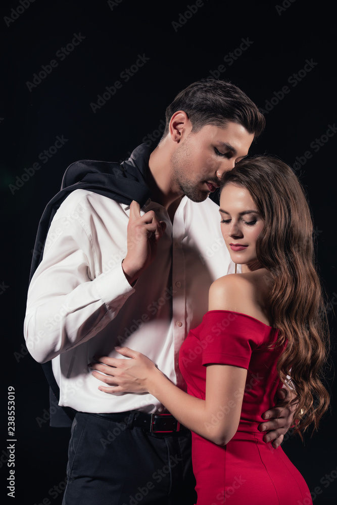 beautiful romantic couple in formal wear hugging isolated on black beautiful romantic couple in formal wear hugging isolated on black