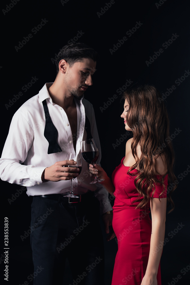 beautiful couple clinking red wine glasses isolated on black beautiful couple clinking red wine glasses isolated on black