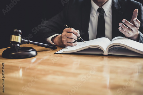 Male lawyer or judge working with contract papers, Law books and wooden gavel on table in courtroom, Justice lawyers at law firm, Law and Legal services concept