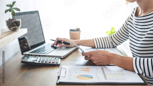 Female accountant analyzing financial graph data with calculator