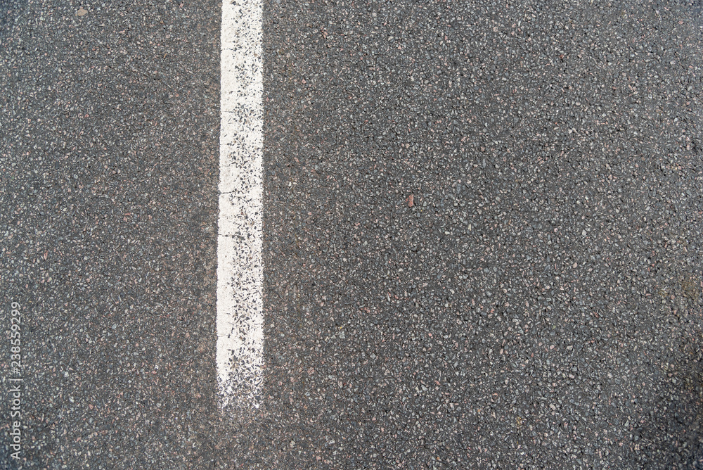 Asphalt road texture, Grainy background,small chopped stones black and gray with a white guide line road Asphalt road texture, Grainy background,small chopped stones black and gray with a white guide line road