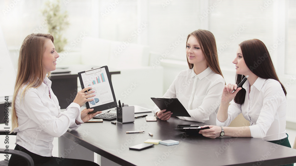 Fototapeta premium young employees are talking sitting behind a Desk.