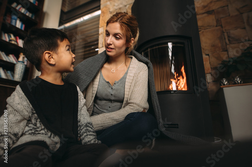 Young mother and son by a fireplace at home