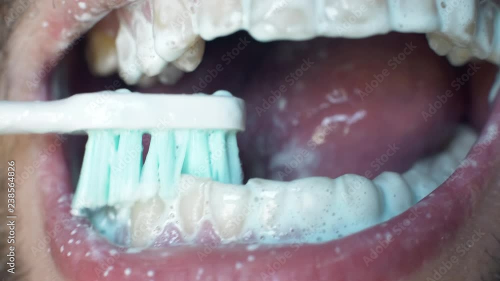 Man's open mouth and brushes his teeth in morning. Close up white man