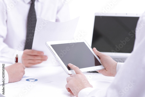 close up.the businessman uses a digital tablet to find partners.business concept