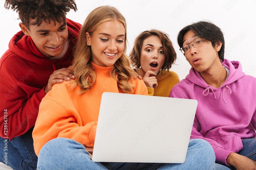 Group of friends students isolated over white wall background using laptop computer. Group of friends students isolated over white wall background using laptop computer.