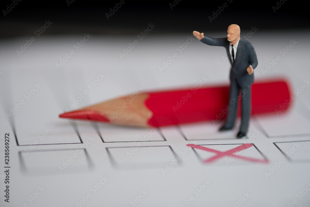 Miniature people of a politician standing on election ballot Miniature people of a politician standing on election ballot