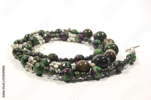 Handmade necklace of green color from multi-colored natural stones on a white background. Beautiful decoration for women.