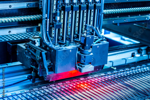 Close-up surface-mounting machine in progress. SMT (surface-mount technology) is a method for producing electronic circuits. Components are placed directly onto the surface of printed circuit boards. photo