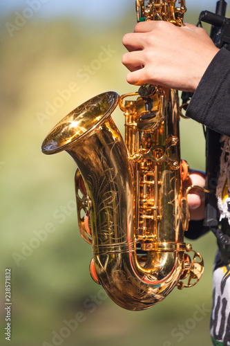 close up of saxophone, young player hands playing soprano sax musical instrument over green background , closeup, can be used for music background