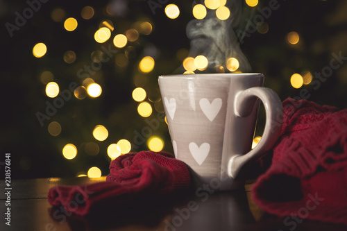 Hot chocolate with marshmallow in front of christmas tree, bokeh